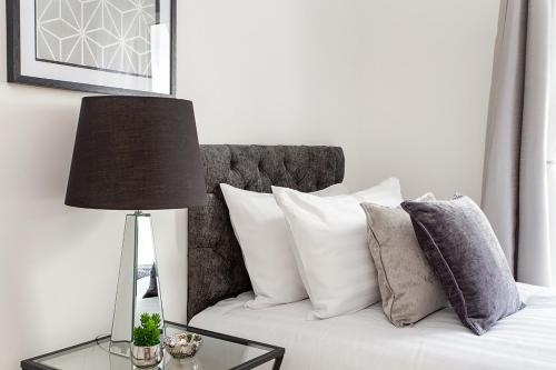 a white couch with pillows and a table with a lamp at Deanery Court Vittrum Suites in Southampton