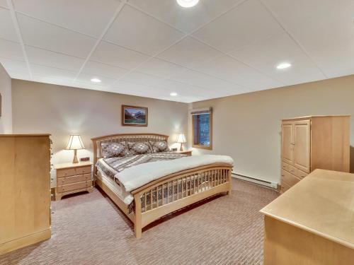 1 dormitorio con 1 cama grande y 2 mesitas de noche en 679 Disciples Village Unit, en Boyne Falls