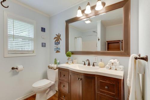 a bathroom with a sink and a toilet and a mirror at Rogers Vacation Rental about 7 Mi to Downtown in Rogers