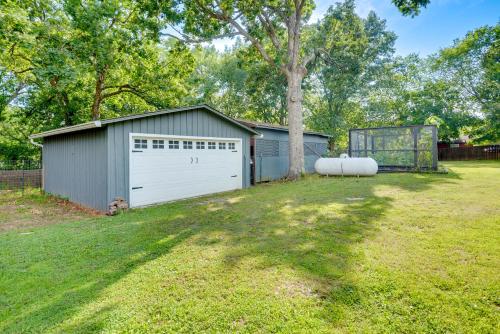 a garage with a tree in a yard at Rogers Vacation Rental about 7 Mi to Downtown in Rogers