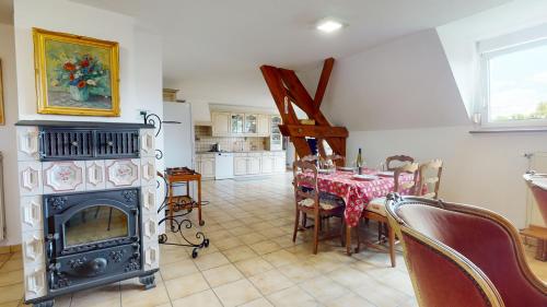 une salle à manger avec une table et une cheminée dans l'établissement Le Clos de Charlotte, à Colmar