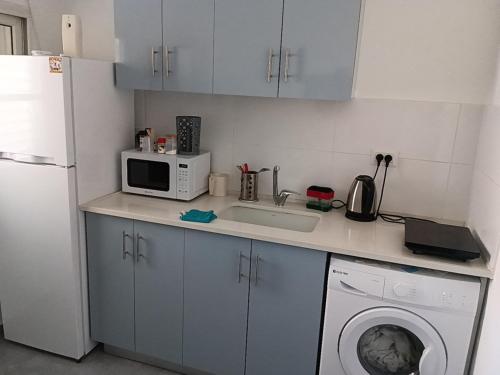 a kitchen with a washing machine and a microwave at רימון יחידות אירוח Vacation units RIMON in Ashqelon