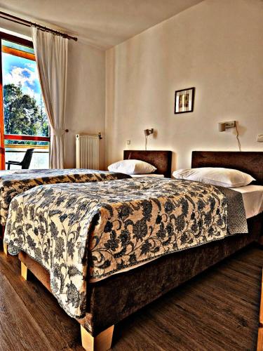 a hotel room with two beds and a window at Hotel Villa Siesta in Smokovce