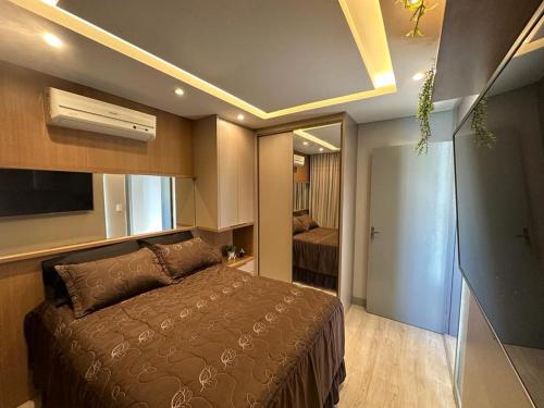 a bedroom with a bed and a door to a room at Lindo Apartamento Inteiro Proximo ao Centro de Criciuma in Criciúma