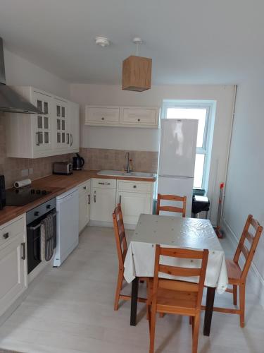 a kitchen with a table and chairs and a refrigerator at Atrium apartments in Bangor