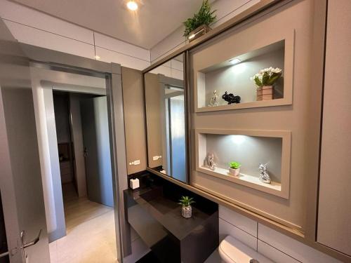 a bathroom with mirrors and plants on the wall at Lindo Apartamento Inteiro Proximo ao Centro de Criciuma in Criciúma
