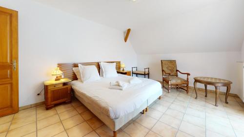 une chambre avec un lit, une chaise et une table dans l'établissement Le Clos de Charlotte, à Colmar
