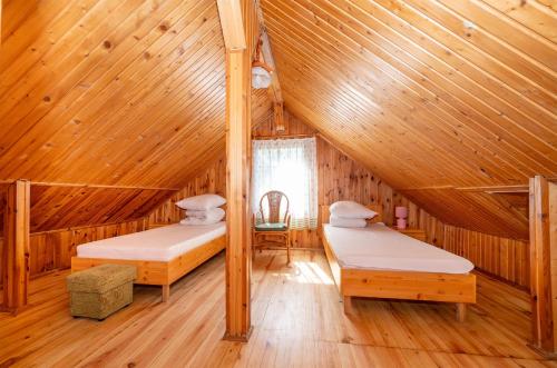 1 dormitorio con 2 camas en una cabaña de madera en Gościniec Jędruś, en Dąbki