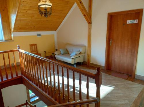 uma sala de estar com uma escada e uma cadeira em PENSJONAT W LESIE em Tuczno