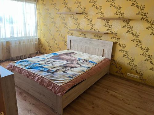 a bedroom with a bed with a painting on the wall at saules street apartment in Ventspils