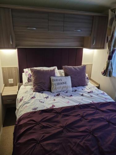 a large bed in a bedroom with a purple headboard at LUXURY CARAVAN 10 mins TO BEACH in Hull