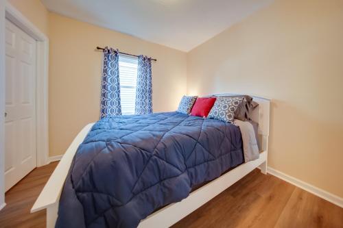 1 dormitorio con cama con edredón azul y ventana en Vacation Rental with Porch and Views of Lake Erie!, en Ashtabula