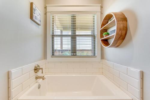 a white bathroom with a tub and a window at Russellville Home Near Hiking and Lake Access! in Russellville