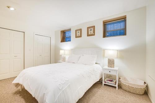 ein weißes Schlafzimmer mit einem weißen Bett und zwei Fenstern in der Unterkunft Lincoln Park Apt Walk to Beach, Shops and Dining! in Chicago