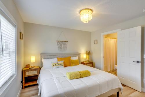 a bedroom with a large white bed and a chandelier at Port Clinton Vacation Rental with Boat Dock and Grill! in Port Clinton