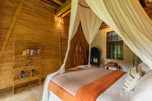 a bedroom with a canopy bed in a cabin at Leaf House 3bds BambooVilla Pool in Bringkit