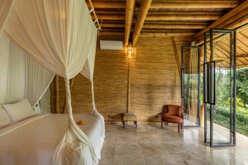 a bedroom with a bed with a mosquito net at Leaf House 3bds BambooVilla Pool in Bringkit