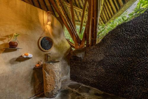 a bathroom with a sink in a room with trees at Leaf House 3bds BambooVilla Pool in Bringkit
