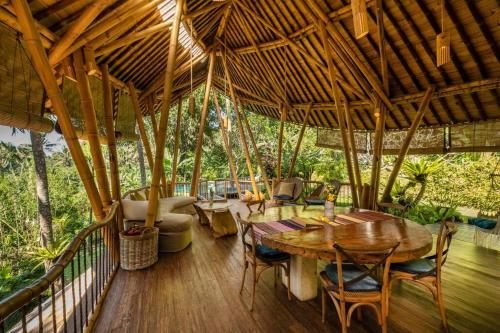 a dining room with a large wooden table and chairs at Leaf House 3bds BambooVilla Pool in Bringkit