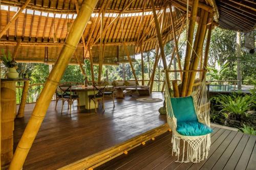 a porch with a gazebo with a green chair at Leaf House 3bds BambooVilla Pool in Bringkit