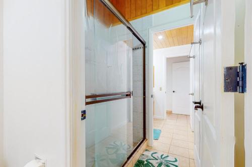 a glass shower in a bathroom with a hallway at Casa Garrobo in Dominical