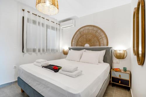 um quarto com uma cama branca e toalhas em Oceanida Terpsis Lyxury Suite em Nikiana
