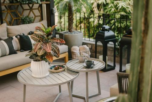 a patio with two tables and a couch and plants at Hotel Apapacho Boutique in San Miguel de Allende