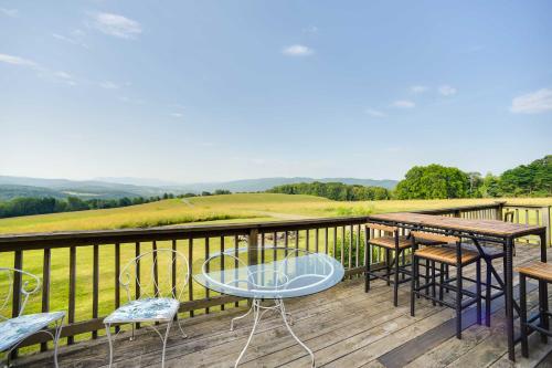 a balcony with tables and chairs and a view of a golf course at Breathtaking Mtn Views Stylish Rustic Retreat! in Bennington