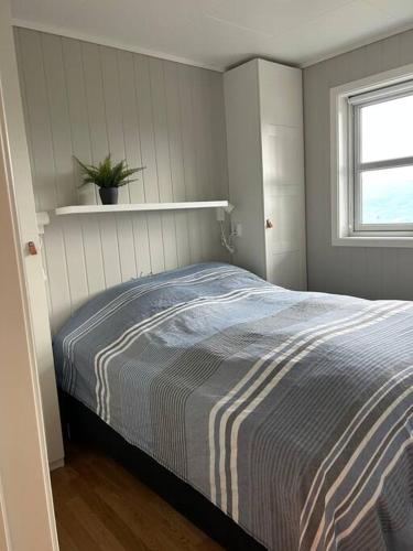 a bedroom with a bed with a striped blanket at Leilighet i Tråstølen Bavallen Voss in Skulestadmo