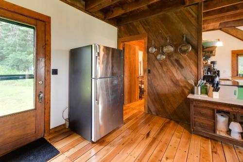a kitchen with a stainless steel refrigerator and wooden floors at Breathtaking Mtn Views Stylish Rustic Retreat! in Bennington