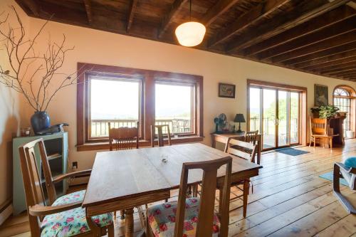 a dining room with a wooden table and chairs at Breathtaking Mtn Views Stylish Rustic Retreat! in Bennington