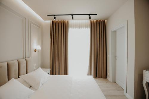 a bedroom with two white beds and a window at Seaside Hotel in Vlorë