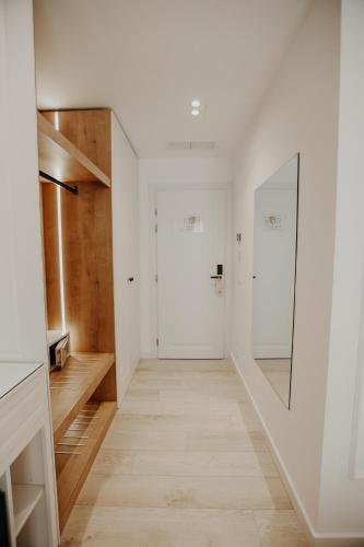 a hallway with white walls and a mirror at Seaside Hotel in Vlorë
