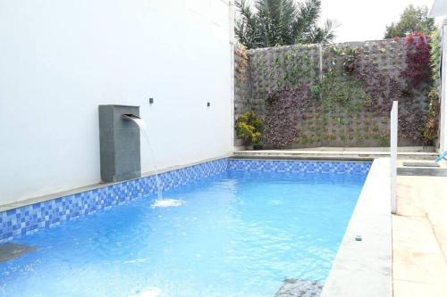 - une piscine avec une fontaine dans la cour dans l'établissement Villa 55 with Pool, Karaoke and Rooftop, à Bogor