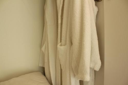 a white towel hanging on a wall next to a bed at Rito Hall da Serra in Leiria
