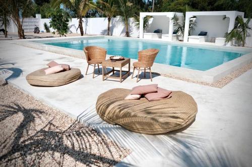 a swimming pool with two chairs and a table next to a pool at Antares Villa in Kiwengwa