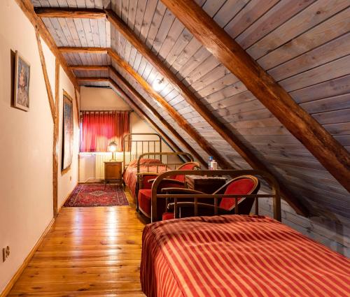 Cette chambre mansardée comprend 3 lits et un plafond en bois. dans l'établissement Frankówka, à Łagów