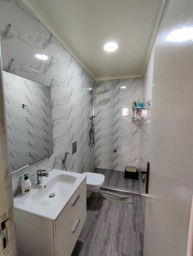 een witte badkamer met een wastafel en een toilet bij Very Nice Relaxing Apartment In Agadir El Houda in Agadir