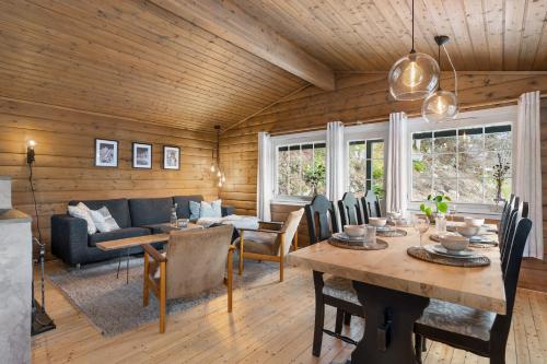 uma sala de estar com uma mesa e um sofá azul em Lyngebu. Nice family cabin with sea view. em Lyngdal