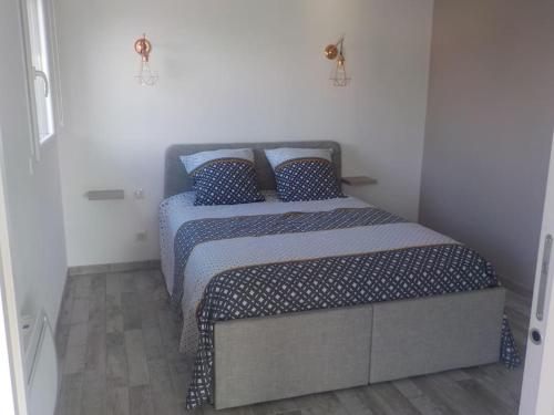 niewielka sypialnia z łóżkiem z niebieskimi poduszkami w obiekcie STUDIO LOSANJOS w mieście Brens