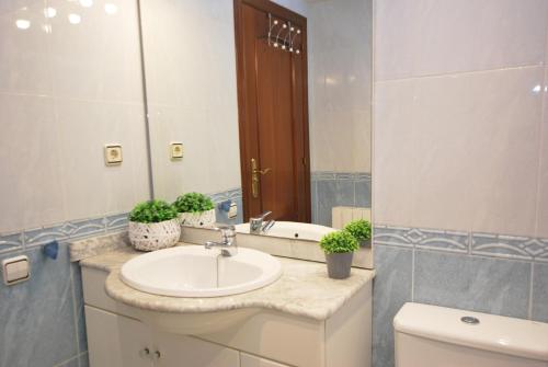 uma casa de banho com um lavatório, um WC e um espelho. em Gaudi Contemporani em Mataró