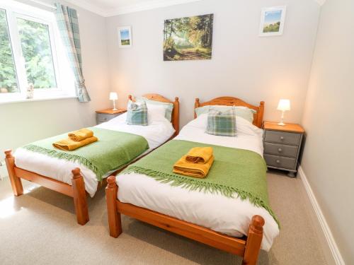 two twin beds in a bedroom with two towels at Farm View Lodge in Stroud