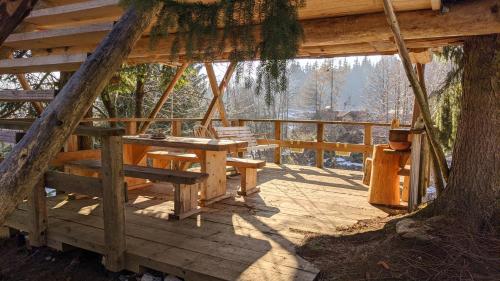 una terraza de madera con una mesa y un árbol en Get your zen among the trees en Stahovica