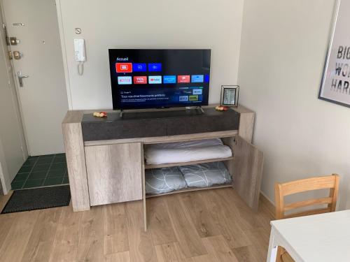- une télévision sur un support en bois dans l'établissement Mission 36 - Wifi - Calme et tranquillité - Résidence Beauséjour, à Troyes