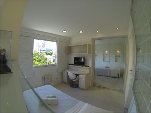 a white bathroom with a sink and a mirror at The Place Leblon in Rio de Janeiro