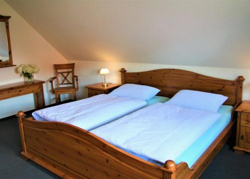 a bedroom with a large wooden bed with two pillows at Plater Hermann in Lüchow