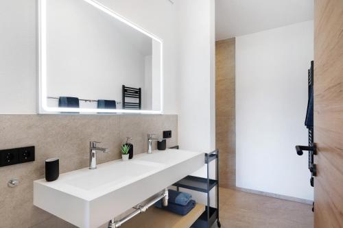 Un baño con un lavabo blanco y un espejo. en Stackler54 - mit Balkon, en Neustift im Stubaital