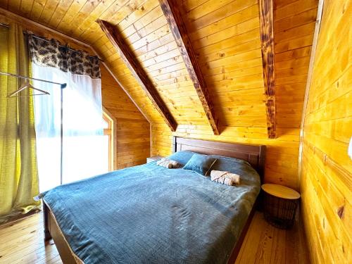 1 dormitorio con 1 cama en una cabaña de madera en Дом в Жабляке с шикарным видом на Дурмидор en Žabljak