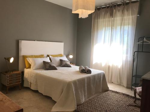 a bedroom with a large white bed with a window at Casa lu Monaco tranquillità a due passi dal mare in Porto dʼAscoli