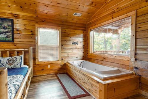 ein Badezimmer mit einer Badewanne in einem Blockhaus in der Unterkunft Blackberry Bijou in Pigeon Forge